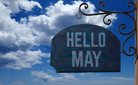 Hello may wooden vintage sign hanging over blue sky with clouds