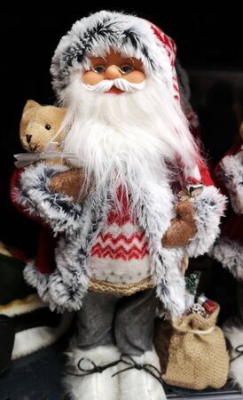 Santa Claus as toy with glasses and holiday costume. Traditional Christmas toy fair.の写真素材
