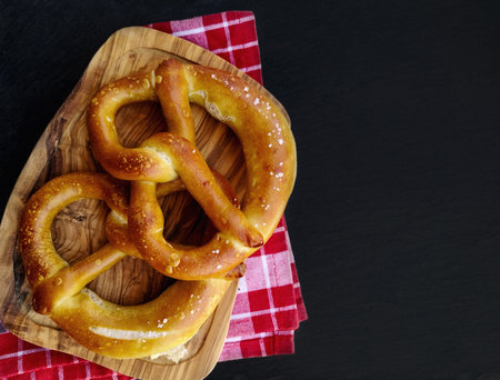 Fresh baked homemade pretzel with sea salt on stone tableの写真素材