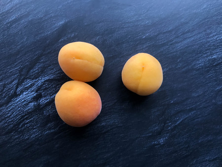 three delicious orange apricots on the tableの写真素材