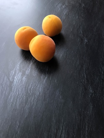 three delicious orange apricots on the tableの写真素材