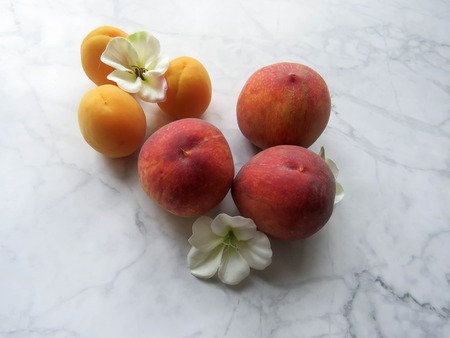 Peaches and apricots lie beautifully on the tableの写真素材