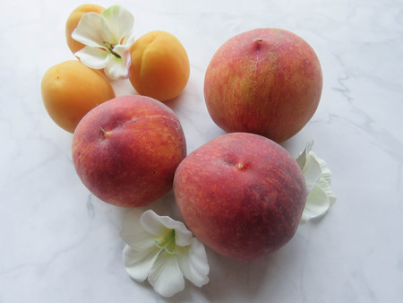 Peaches and apricots lie beautifully on the tableの写真素材
