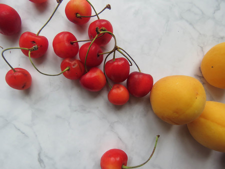 apricots and sweet cherries beautifully lie on the tableの写真素材