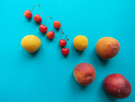 Peaches, apricots and sweet cherries beautifully lie on the tableの写真素材