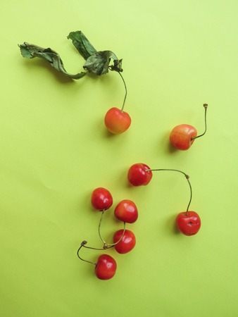 red cherries beautifully lie on a yellow tableの写真素材