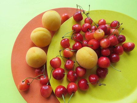 apricots and sweet cherries beautifully lie on a plateの写真素材