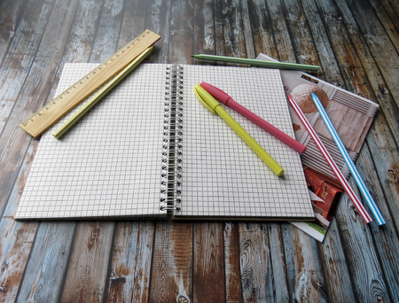 the notebook, pens, pencils and ruler on the tableの写真素材
