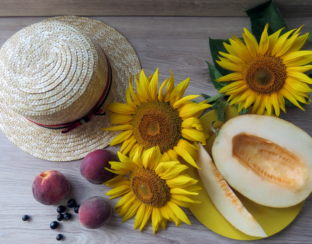 The melon in a plate on a table with sunflowersの写真素材