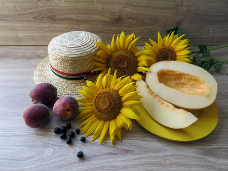 The straw hat and sunflowers on wooden backgroundの写真素材