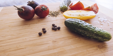 red and yellow tomatoes sliced and cucumber on a wooden board. healthy eating. eco-friendly products. Organic Food. Style Top View Group Objectsの写真素材