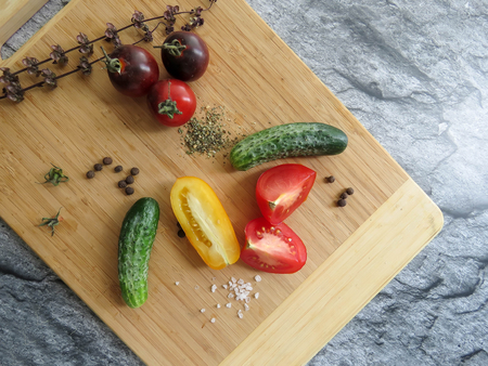 red and yellow tomatoes sliced and cucumber on a wooden board. healthy eating. eco-friendly products. Organic Food. Style Top View Group Objectsの写真素材