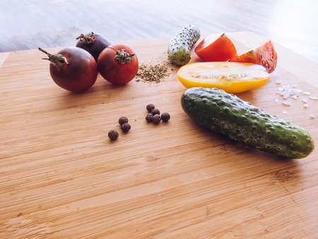 red and yellow tomatoes sliced and cucumber on a wooden board. healthy eating. eco-friendly products. Organic Food. Style Top View Group Objectsの写真素材
