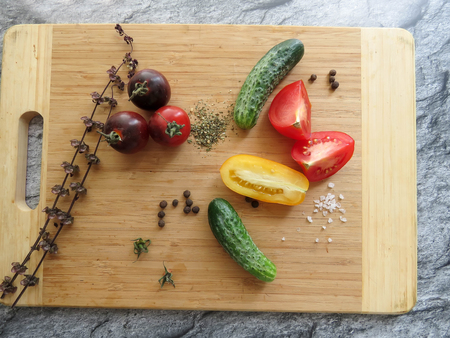 red and yellow tomatoes sliced and cucumber on a wooden board. healthy eating. eco-friendly products. Organic Food. Style Top View Group Objectsの写真素材