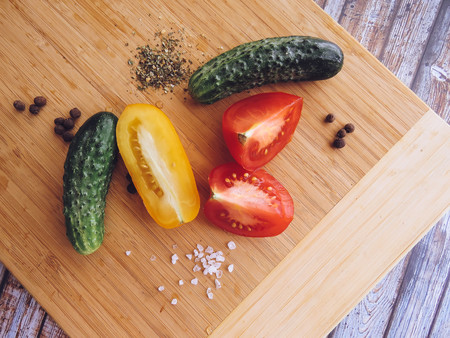 red and yellow tomatoes sliced and cucumber on a wooden board. healthy eating. eco-friendly products. Organic Food. Style Top View Group Objectsの写真素材