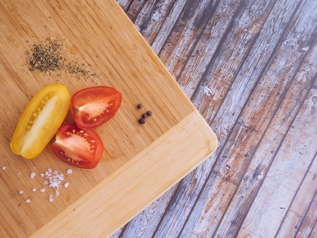red and yellow tomatoes sliced on a wooden board. healthy eating. eco-friendly products. Organic Food. Style Top View Group Objectsの写真素材