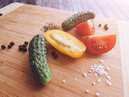 red and yellow tomatoes sliced and cucumber on a wooden board. healthy eating. eco-friendly products. Organic Food. Style Top View Group Objectsの写真素材