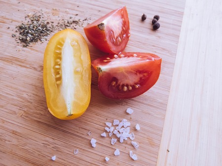 red and yellow tomatoes sliced on a wooden board. healthy eating. eco-friendly products. Organic Food. Style Top View Group Objectsの写真素材