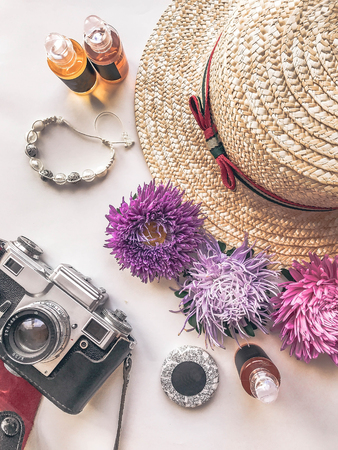 Stylized feminine flatlay with camera, hat, bunch of aster, bracelet mock up isolated on white top view. Woman accessories from above. Group Objectsの写真素材