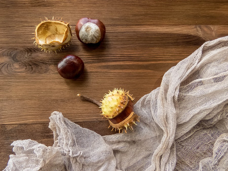 Ripe chestnuts on old wooden table close up with copy space. autumn background copy space. group of objects. Style Top Viewの写真素材