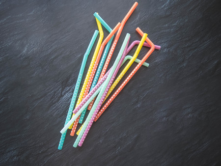 Drinking paper colorful straws for summer cocktails on dark background with copy space. Top view. group of objectsの写真素材