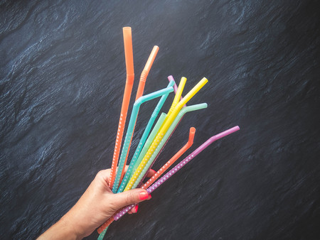 Drinking paper colorful straws in hand for summer cocktails on dark background with copy space. Top view. group of objectsの写真素材