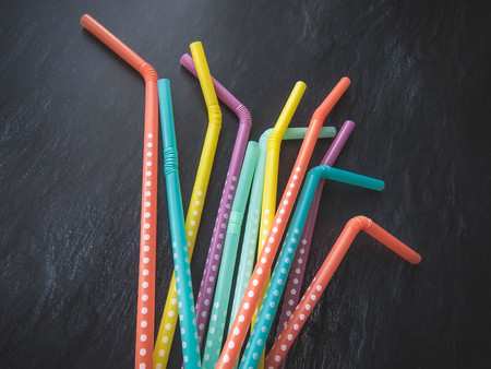 Drinking paper colorful straws for summer cocktails on dark background with copy space. Top view. group of objectsの写真素材