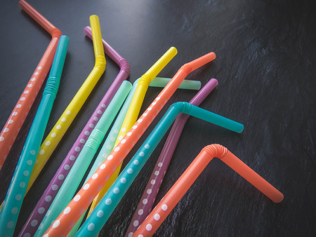 Drinking paper colorful straws for summer cocktails on dark background with copy space. Top view. group of objectsの写真素材