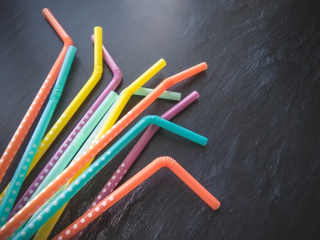 Drinking paper colorful straws for summer cocktails on dark background with copy space. Top view. group of objectsの写真素材