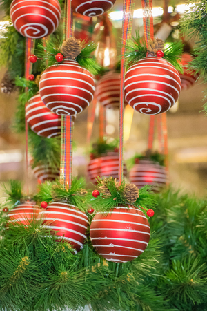 Christmas holiday background. red balls hanging from a decorated on christmas tree with bokeh, copy space. group of objectsの写真素材