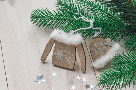 Wooden christmas decoration - christmas hat, sweater on a white wooden background with christmas tree space for textの写真素材