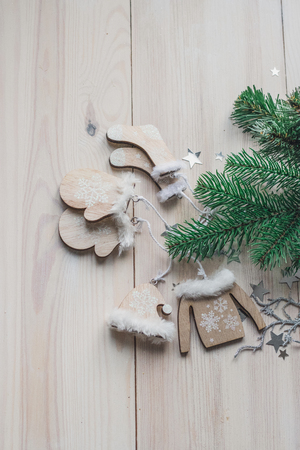 Wooden Christmas decorations - Christmas mittens, hat, sweater and socks on a white wooden background with a Christmas tree space for textの写真素材