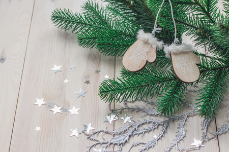 Wooden christmas decoration - christmas mitten on a white wooden background with christmas tree space for textの写真素材