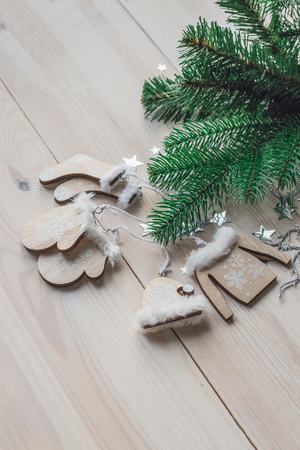Wooden Christmas decorations - Christmas mittens, hat, sweater and socks on a white wooden background with a Christmas tree space for textの写真素材
