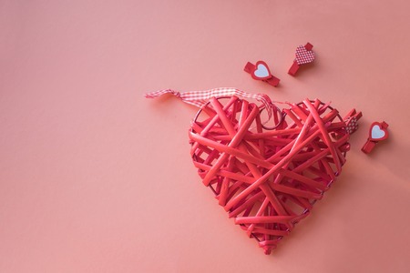 Valentine's day concept. Wicker heart on a coral background. field for text. top viewの写真素材
