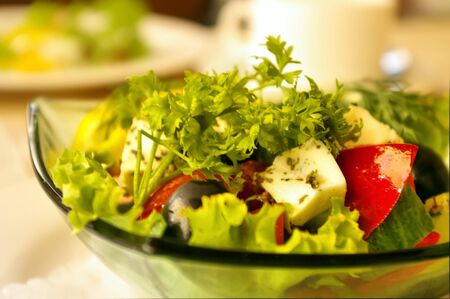 The Greek salad in glasswares on a white dish at restaurantの写真素材