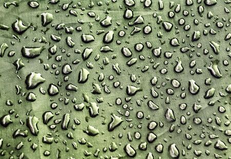 Abstract background with green water drops on the rough fabricの写真素材