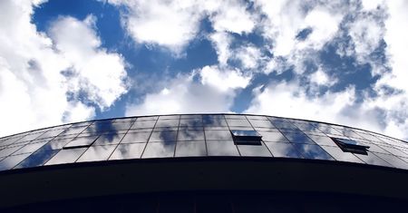 Office building on the blue sky background with cloudsの写真素材