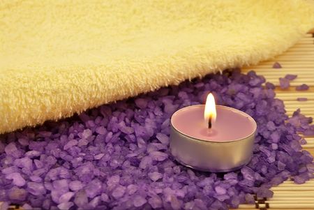 Heap of violet bath salt wiih candle and yellow towelの写真素材