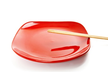 Red square empty dish with chinese sticks isolated on whiteの写真素材