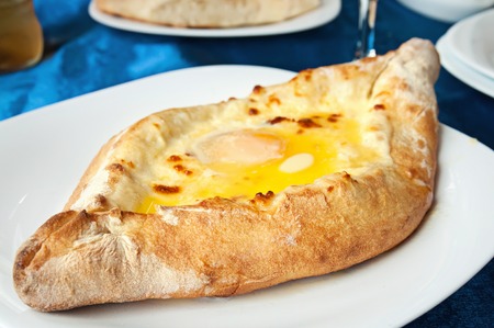 Adzhar khachapuri - traditional georgian pastry on dish in restaurantの写真素材