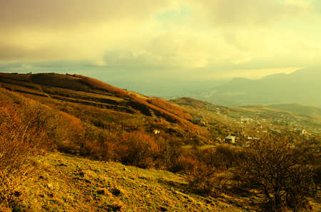 Rural sunset landscape with mountains and dramatic skyの写真素材