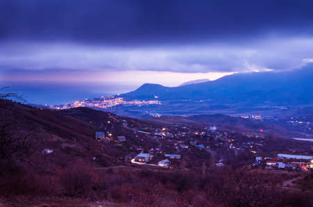 Landscape with night city Alushta before  sunrise in violet colors