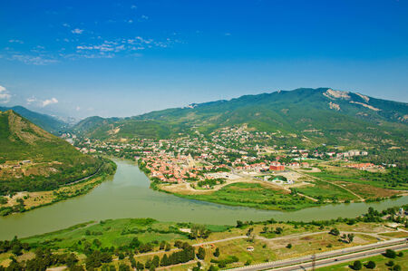 Old georgian town  Mtskheta in the mountains with blue sky and green hillsの写真素材
