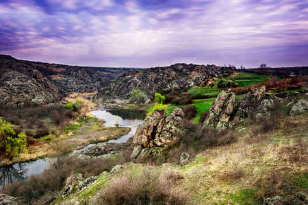 Sunrise at canyon with river, hills and dramatic sky with reflection