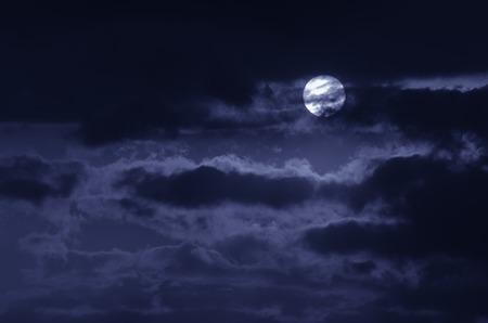The moon on the dark sky among the clouds, natural abstract blue background