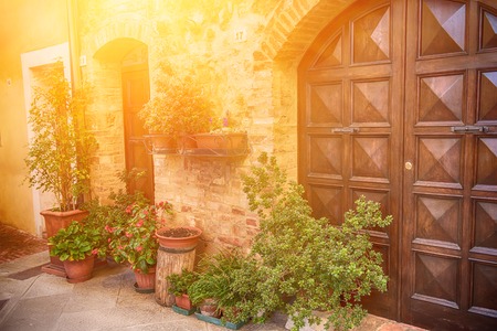 View of the ancient old european city. Street of Pienza, Italy with wooden doors. Sunny travel background.の写真素材