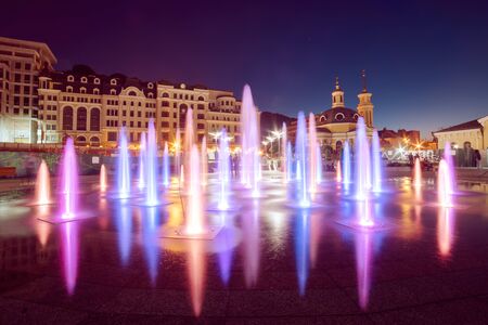 Musical fountain with colorful illumination at night with reflection. Ukraine, Kiev. Travel...