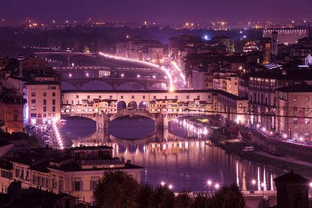 Night view of Florence city with Ponte Vecchio over river Arno and illumination. Travel sightseeing background.の写真素材