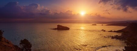 Cyprus beautiful sunrise at the sea with rocks and cloudy sky, natural panoramic background. Summer vacation conceptの写真素材